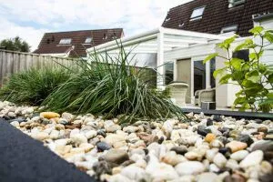 Detailopname van siergrind met polletjes siergrassen langs een tuinrand
